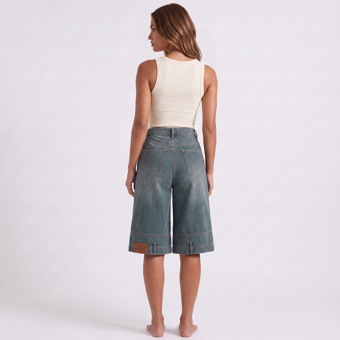 Retro high waist wide-leg knee-length denim shorts in washed blue-grey indigo - back view showing the angular western yoke seam, plain seat and patch pockets low on each leg