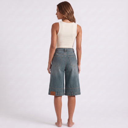 Retro high waist wide-leg knee-length denim shorts in washed blue-grey indigo - back view showing the angular western yoke seam, plain seat and patch pockets low on each leg