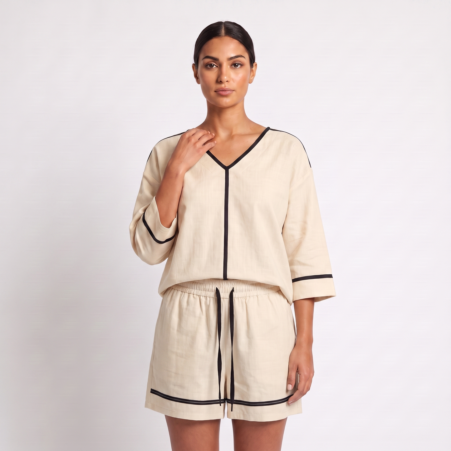 Detail of the top - V-neck with black tape trim, centre-front tape and sleeve cuff bands