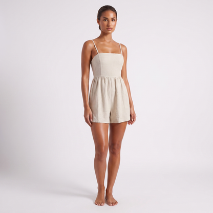 Casual Linen Romper in Apricot oatmeal linen - full length three-quarter view with the front of the garment to camera, showing the bandeau bodice, waist seam and wide gathered shorts hemmed above the knee.
