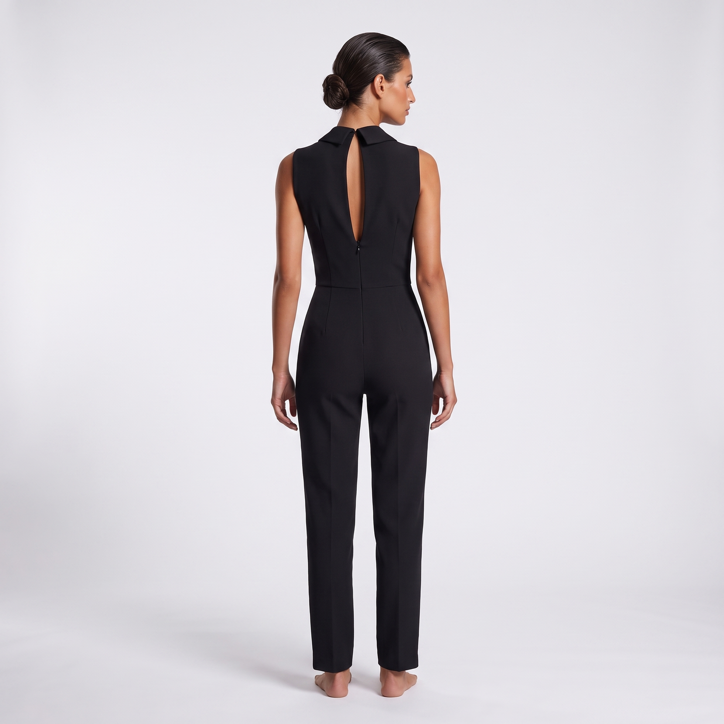 Black jumpsuit back view - standing collar tips, long centre-back keyhole slit and concealed zip