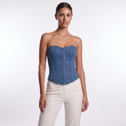 Denim strapless overbust corset vest in washed indigo blue, full front view on model styled with cream trousers