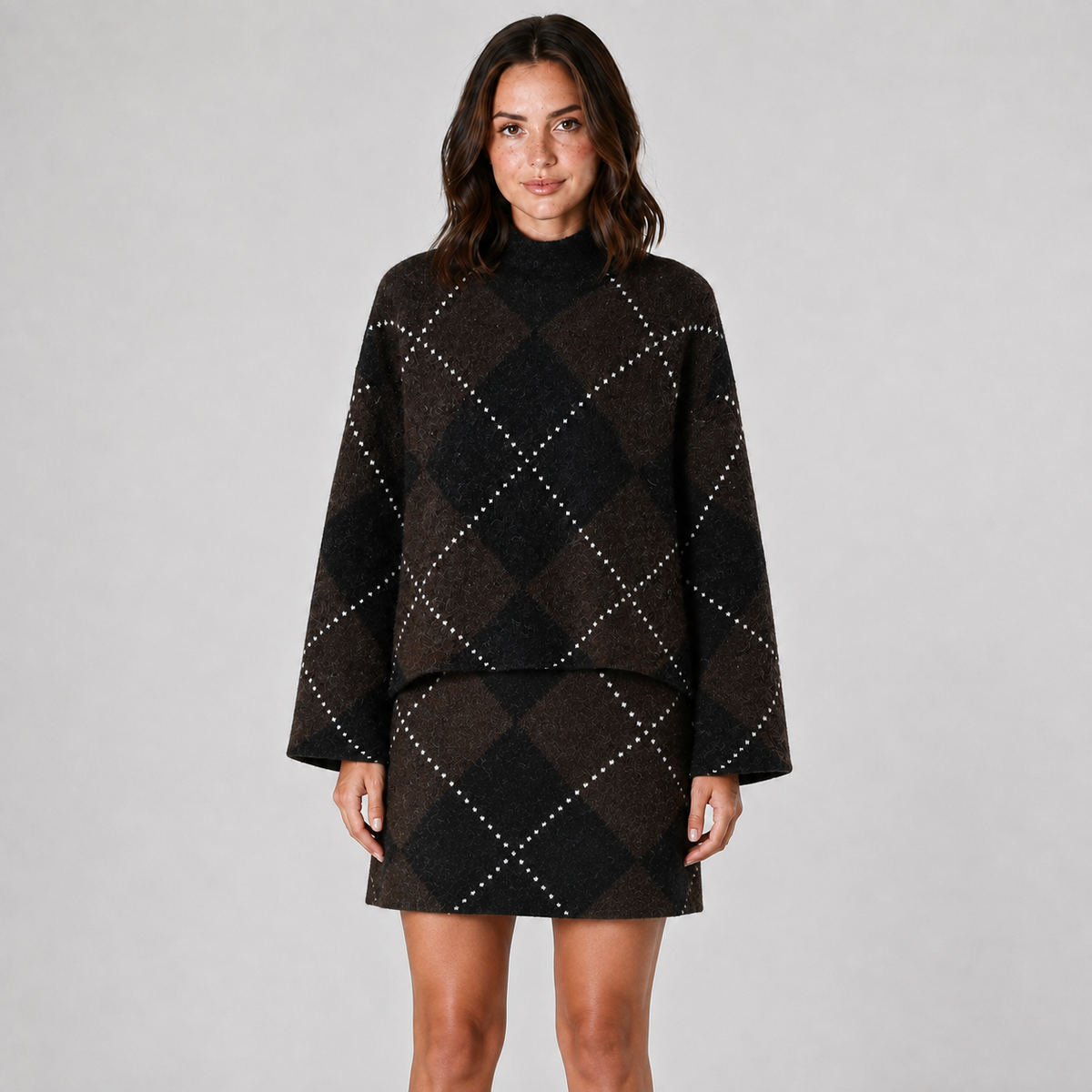 Model wearing the matching dark brown and black argyle mock-neck knit top and mini skirt, front view.